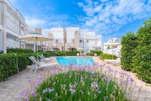 a courtyard with a swimming pool and purple flowers at Residence Lucrezia in Nardò