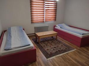 a room with two beds and a table in it at Pandora Apartments Sarajevo in Sarajevo