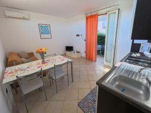 a kitchen and living room with a table and a couch at Residence Lucrezia in Nardò