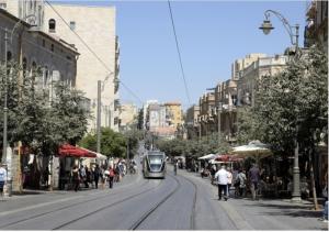 a tram on a street in a city with people at Koresh 10 -revelin suite in Jerusalem +8 photos