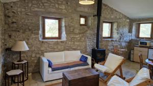 a living room with a white couch and a stone wall at Gîte de Branchou in Coux +15 photos