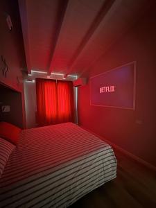 a red bedroom with a bed with a red curtain at Dimora Bollicine in Colombaro
