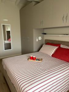 a bedroom with a bed with red and white stripes at Dimora Bollicine in Colombaro