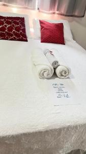 a bed with towels on it with a note on it at Chalé da Ana in Tutóia