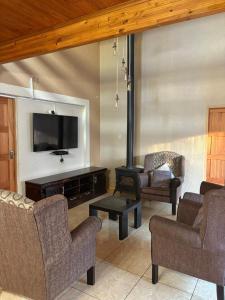 a living room with chairs and a flat screen tv at Swakhanya Haus in Vereeniging