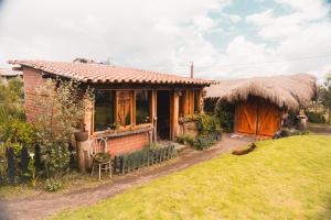 a small house with a grass roof at COTOPAXI Wasi Andina Lodge in Latacunga