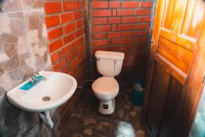 a bathroom with a toilet and a sink at COTOPAXI Wasi Andina Lodge in Latacunga
