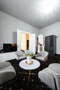 a living room with chairs and a table with a vase of flowers at Palazzo Bellariva Dimora in Cluj-Napoca