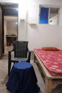 a room with a bench and a chair and a table at Mahadev Guest House in Deoghar