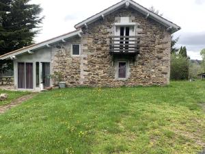 a stone house with a lawn in front of it at Maison de caractère in Saint-Vert