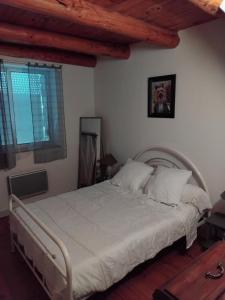 a bedroom with a large bed with white sheets at Maison de caractère in Saint-Vert