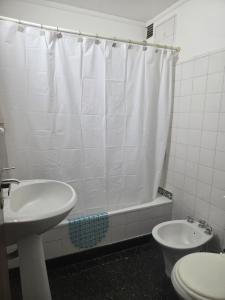 a bathroom with a sink and a toilet and a shower curtain at Plaza 23 in Bahía Blanca +14 photos