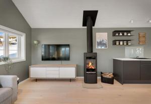 a living room with a fireplace and a tv at Panoramic View of Voss - Private Cabin & Patio in Vossevangen