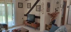 a living room with a television on a wooden table at Diogenis villa in Vourvourou