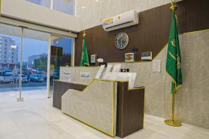 a lobby with a counter with a clock and a flag at بالم بوتيك السلامه - Palm Boutique Alsalamah in Jeddah