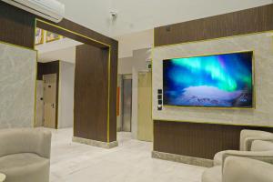 a living room with a large flat screen tv on a wall at بالم بوتيك السلامه - Palm Boutique Alsalamah in Jeddah
