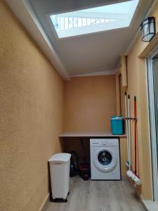 a laundry room with a washing machine and a skylight at Rosa de la Sal in La Mata