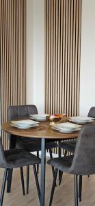 a wooden table with chairs and plates on it at Ferienwohnung Nideggen, Eifel, Nähe Ruhrsee, Nationalpark in Nideggen