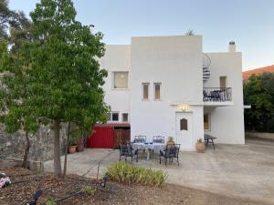 a large white house with a table and chairs at Ellie's Kantanos in Kántanos