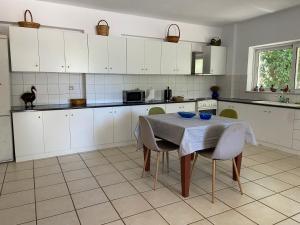 a kitchen with white cabinets and a table with chairs at Ellie's Kantanos in Kántanos +15 photos