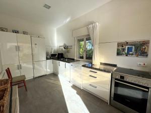 a large kitchen with white cabinets and a window at Casa Los Campones en Asturias VV-3585-AS in Nava