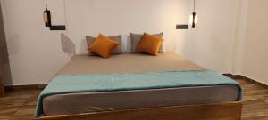 a bed with orange pillows on it in a room at Villa #1 in Unawatuna