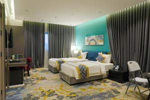 a hotel room with two beds and a desk at بالم بوتيك السلامه - Palm Boutique Alsalamah in Jeddah