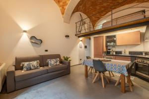 a kitchen and living room with a couch and a table at Via Roma 106 Apartment in Sassari