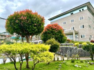 a building with trees in front of a building at Baguio BELL Staycation in Baguio