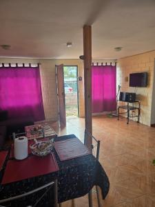 a living room with pink curtains and a table at Margaret in Combarbalá