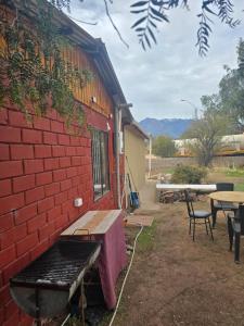 a red brick building with a bench next to a table at Margaret in Combarbalá