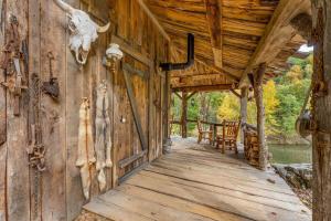 a porch of a log cabin with a table and chairs at Squatter's Cabin (Off-Grid): Includes 1-UTV in Jasper
