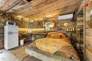 a bedroom with a bed in a wooden cabin at Squatter's Cabin (Off-Grid): Includes 1-UTV in Jasper