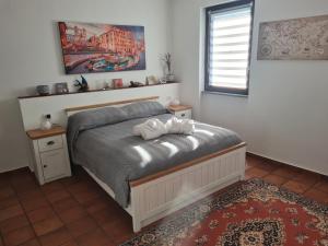 a bedroom with a bed and a window at La piazzetta del sole in Pettinengo +9 photos