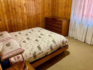 a small bedroom with a bed and a dresser at Baita Azzurro in Isolaccia