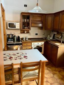 a kitchen with wooden cabinets and a table with chairs at Baita Azzurro in Isolaccia