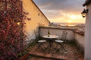 a table with two chairs and a bottle of wine at VesConte Residenza D'epoca dal 1533 in Bolsena