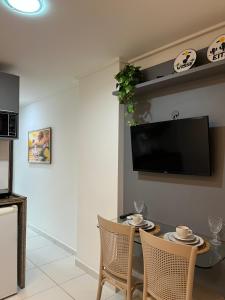 a dining room with a table and a tv on a wall at APART HOTEL MANAIRA PALACe 2 in João Pessoa