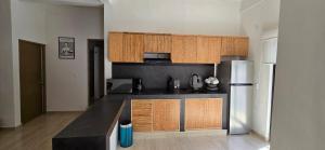 a kitchen with wooden cabinets and a refrigerator at New, modern, amazing terrace in Taxco de Alarcón +8 photos