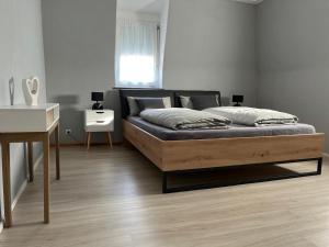 a bed in a bedroom with a desk and a bed sidx sidx sidx at Murgtalhouse Ferienwohnungen in Murg +24 photos