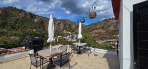 a balcony with tables and chairs and a view of a mountain at New, modern, amazing terrace in Taxco de Alarcón