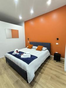 a bedroom with a large bed with an orange wall at Casa con vista in Ariccia