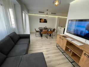 a living room with a couch and a large flat screen tv at Alicante City Suite 2 in Alicante