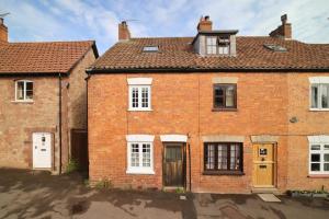 an old brick house with white doors and windows at Beautiful Cottage & Garden Quantock Hills in Nether Stowey