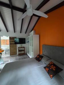 a bedroom with a large bed with a ceiling fan at L'Abri BEAUCI- TURLET in Goyave