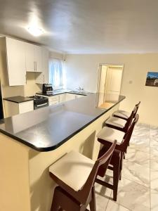a kitchen with a counter and chairs in a room at Vimbainashe Villas in Umtali