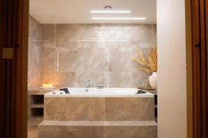 a bathroom with a tub and a stone wall at Welcome to Hidden Spa in Wissous