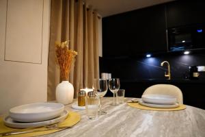 a table with plates and glasses and a vase with flowers at Welcome to Hidden Spa in Wissous