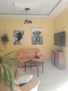 a living room with a couch and a tv at Villa Sara DIALLO in Ngaparou