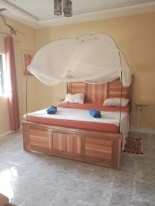 a bedroom with a bed with a canopy at Villa Sara DIALLO in Ngaparou